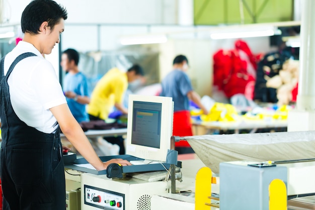 Arbeitskraft auf einer Maschine in der asiatischen Fabrik