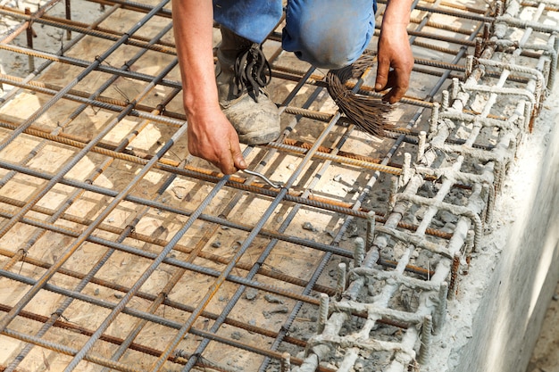 Arbeitskraft bindet Stahlverstärkungsstangen mit Draht.