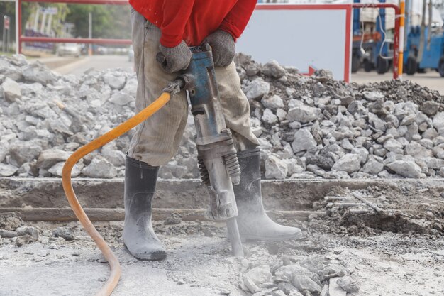 Arbeitskraft, die Bau bohrenden Kleber aus den Grund verwendet