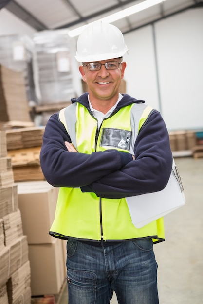 Arbeitskraft, die Schutzhelm im Lager trägt