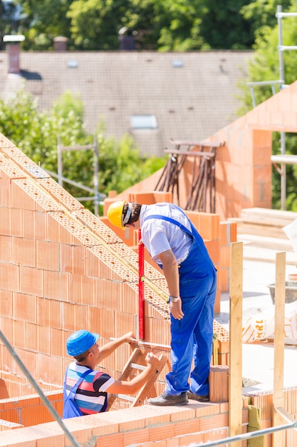 Arbeitskraft, die Wände auf Baustelle überprüft