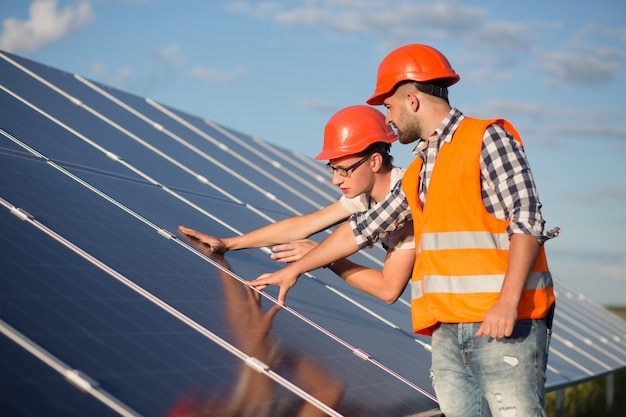 Arbeitskraft und Vorarbeiter, die Sonnenenergieplatte warten.