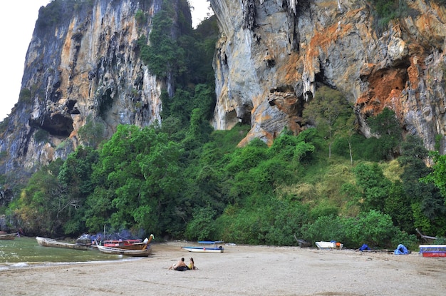 Arbeitskraftführer Einheimische, die hölzernes Langschwanzboot segeln, stoppen für senden, empfangen thailändische und ausländische Reisende, Reisebesuch, Erholung, entspannen sich am Sandstrand in Ao Nang Railay Bay am 23. April 2011 in Krabi Thailand