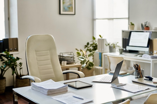 Arbeitsplatz des Managers mit Laptop und Stapel Dokumenten auf dem Tisch im Büro