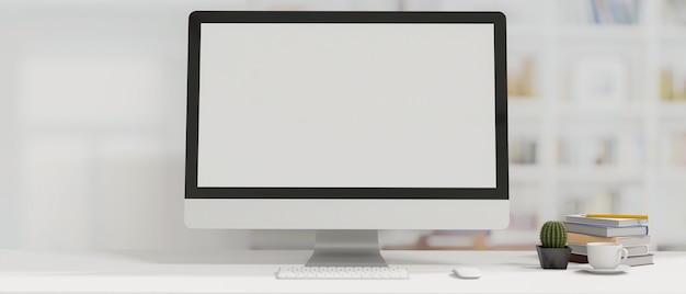 Arbeitsplatz im minimalistischen Stil mit Desktop-Computer in Buchkaktus und Kaffeetasse mit leerem Bildschirm