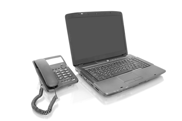 Arbeitsplatz-Laptop mit Telefon, isoliert auf weiss