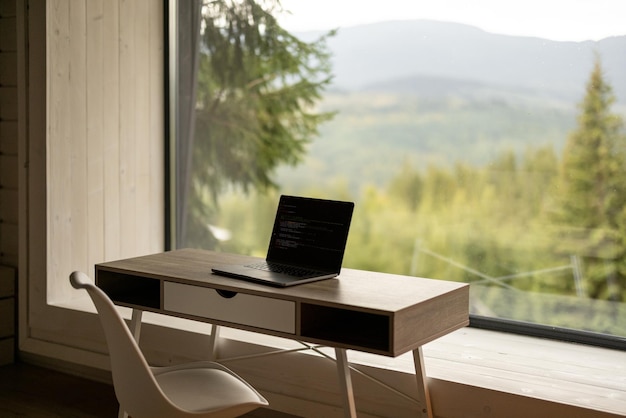 Arbeitsplatz mit Laptop auf dem Tisch im Haus in der Natur