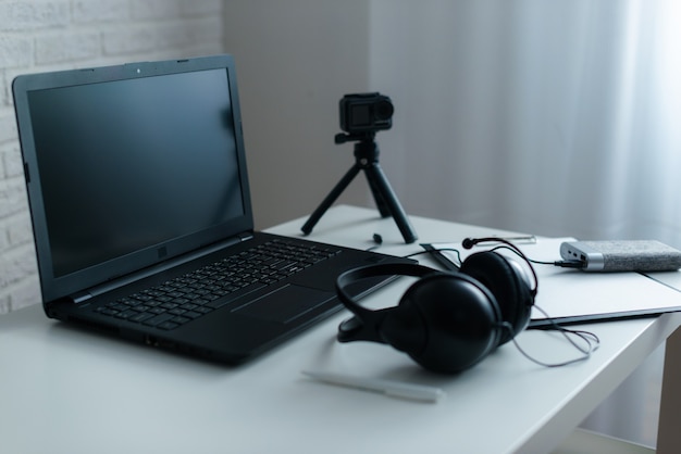 Arbeitsplatz mit Laptop und Kopfhörer auf einem weißen Schreibtisch