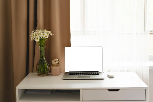 Arbeitsplatz mit Laptop und Wohnkultur auf dem Tisch vor dem Fenster Blick vom vorderen Bürotisch Arbeitsplatz zu Hause