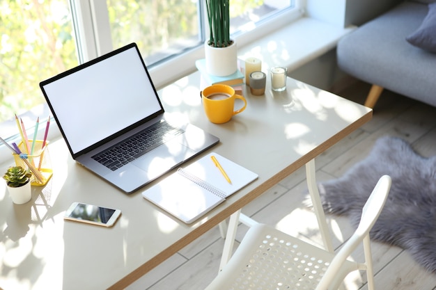 Arbeitsplatz mit modernem Laptop im Inneren des Zimmers