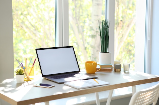 Arbeitsplatz mit modernem Laptop im Inneren des Zimmers