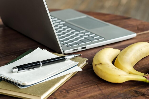 Arbeitsplatz mit modernem Laptop-Notizbuch und Banane