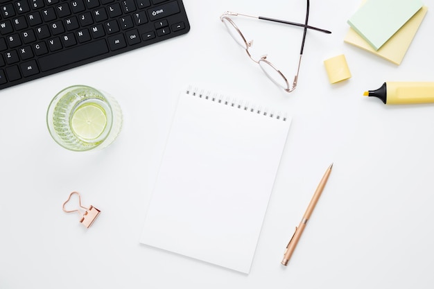 Arbeitsplatz mit weißem Notizbuch und schwarzem Tastaturpapier. Flacher Büroschreibtisch mit Platz für Text