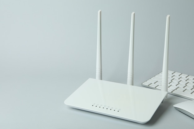 Arbeitsplatz mit WLAN-Router auf grauem Hintergrund