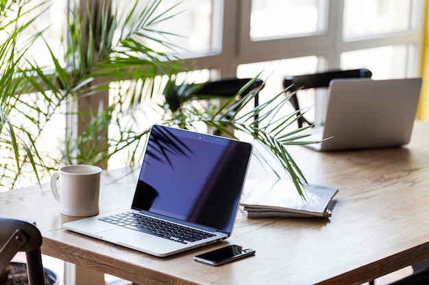 Arbeitsplatz Nahaufnahme von oben auf den komfortablen Arbeitsplatz im Büro mit Holztisch und Laptop