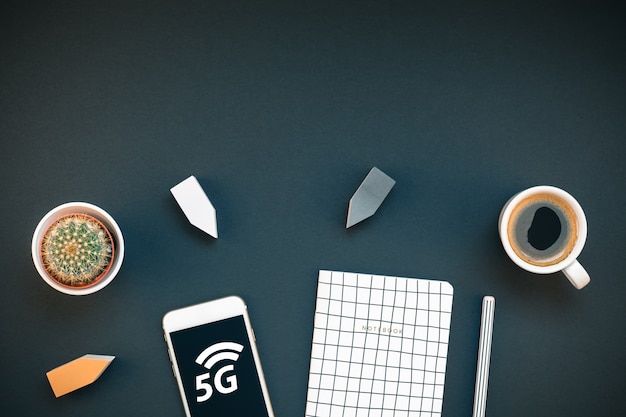 Arbeitsplatz Schreibtisch mit 5G Smartphone und Kaffeetasse