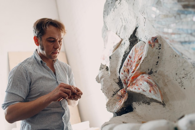 Arbeitsplatzmosaik-Meister, der Smalt-Glasmosaikplatte herstellt Mann-Mosaizist bei der Arbeit