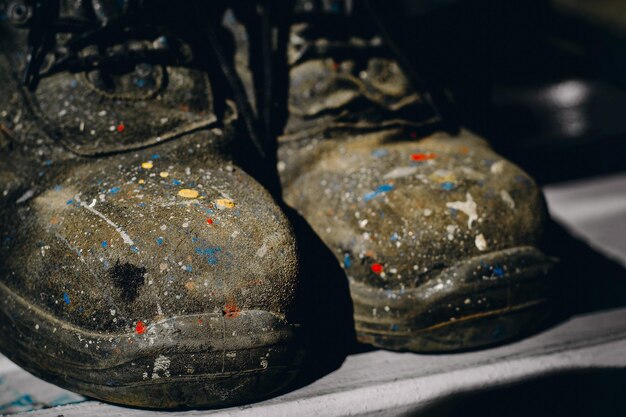 Arbeitsschuhe Alte farbfleckige Stiefel und abgenutzte Industriemalerstiefel Hintergrund