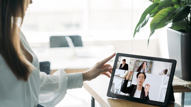 Arbeitsvideo-Chat Digitales Interview Online-Business-Management Weibliche Führungskraft diskutiert Projekt mit diversen Teams auf dem Tablet-Bildschirm zu Hause im virtuellen Büro mit freiem Speicherplatz