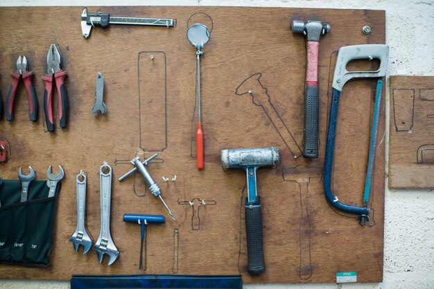 Foto arbeitswerkzeuge, die an holz an der wand hängen