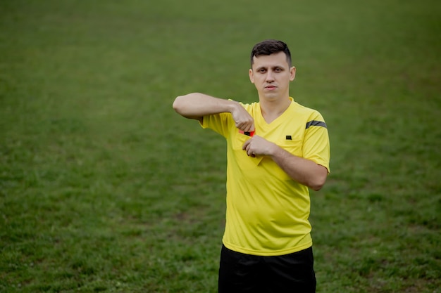 Árbitro de futebol aponta cartão amarelo a jogador em estádio de futebol