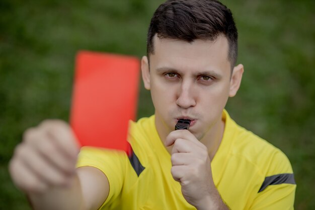 Foto Árbitro mostrando um cartão vermelho para um jogador de futebol ou futebol insatisfeito enquanto joga