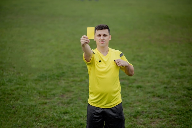 Foto Árbitro que muestra una tarjeta roja a un futbolista o jugador de fútbol disgustado mientras juega.