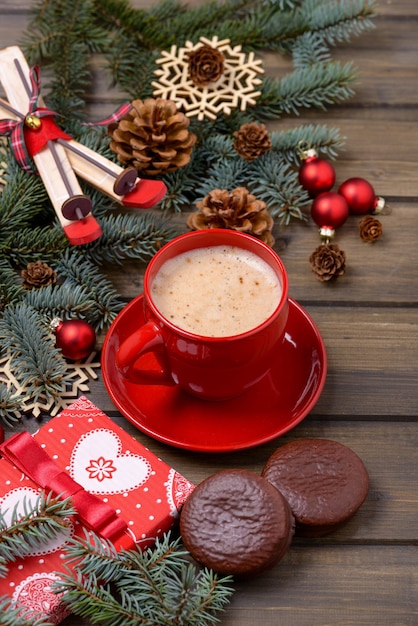 Árbol de abeto y conos con café y galletas sobre fondo de madera