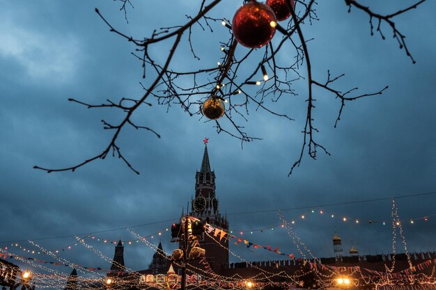 Un árbol con una bola de árbol de Navidad frente a la Torre Spasskaya.