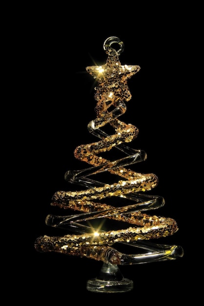 Foto Árbol de cristal de decoración navideña con destellos dorados sobre un fondo negro aislado enfoque selectivo