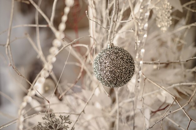 El árbol está decorado con juguetes de colores y una guirnalda. Foto de primer plano en colores cálidos. Ambiente navideño y año nuevo