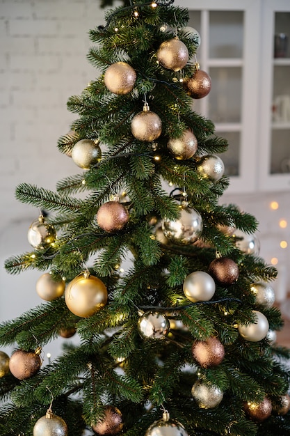 El árbol está decorado con juguetes de colores y una guirnalda. Foto de primer plano en colores cálidos. Ambiente navideño y año nuevo