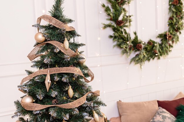 El árbol está decorado con juguetes de colores y una guirnalda. Foto de primer plano en colores cálidos. Ambiente navideño y año nuevo