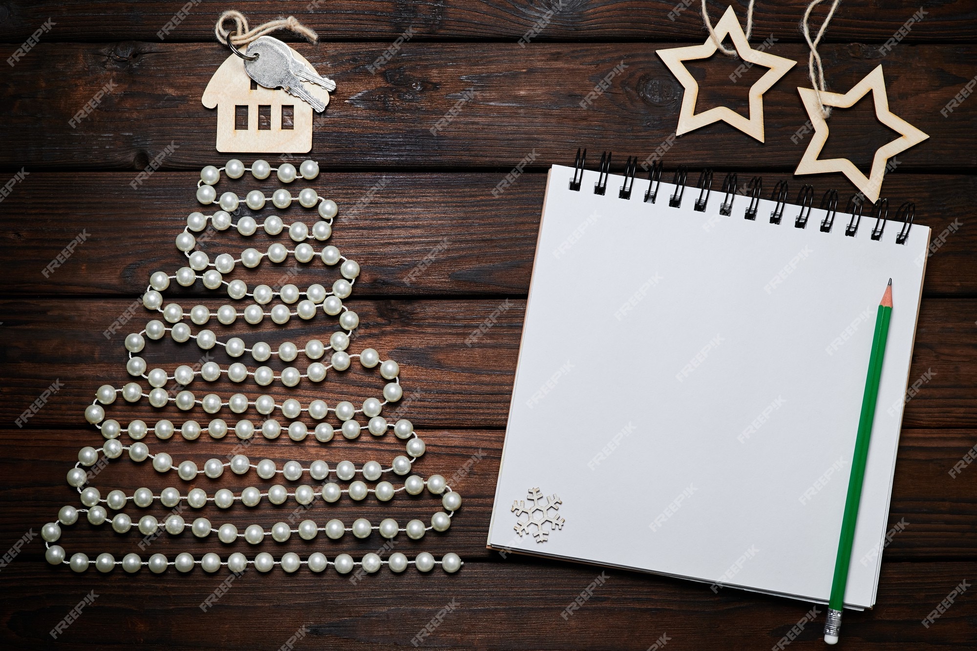 Árbol navidad de abalorios con la casa con llaves en la parte superior y bloc de notas sobre fondo de madera | Foto Premium