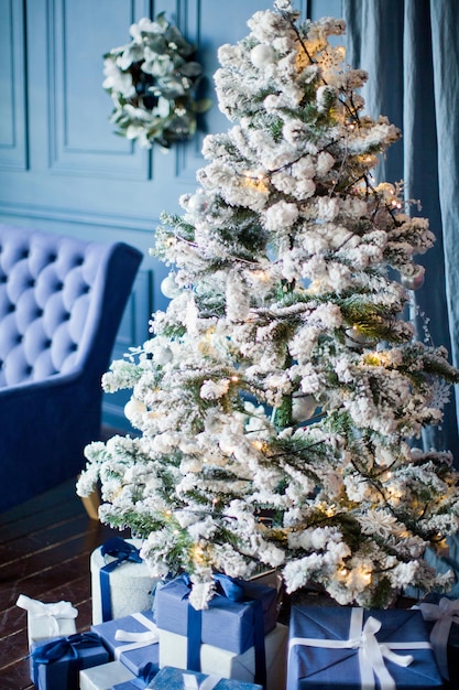 Árbol de Navidad con adornos y cajas de regalo.