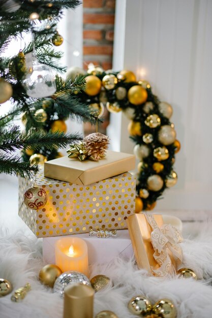 un árbol de Navidad con adornos de oro y plata y una caja de regalos