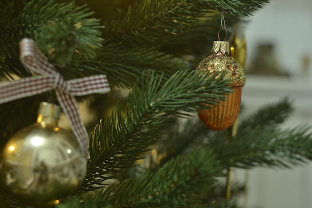 Un árbol de navidad con una bola roja y dorada colgando de él.