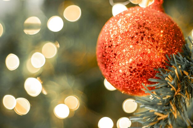 Foto Árbol de navidad bola roja y fondo de bokeh dorado