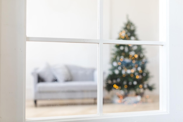 Foto Árbol de navidad brillante a través de la ventana