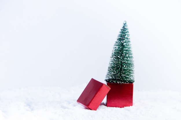 Foto Árbol de navidad en caja de regalo roja sobre nieve