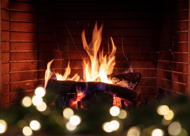 Foto Árbol de navidad y chimenea ardiente hoguera llamas de fuego y luces de decoración festiva