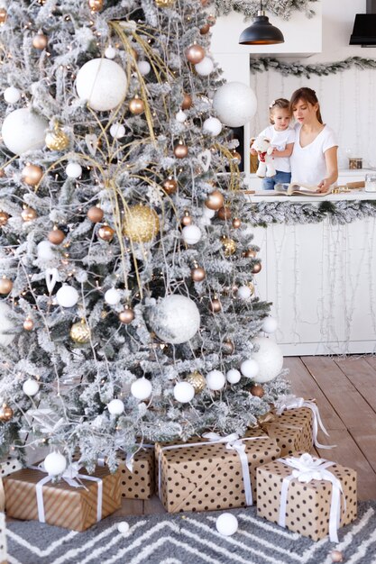 Foto Árbol de navidad en la cocina con gente.