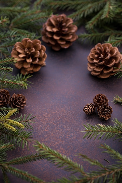 Foto Árbol de navidad y conos sobre fondo marrón