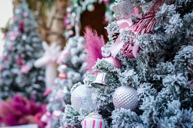 El árbol de Navidad con copos de nieve está decorado con regalos de bolas y regalos en tema rosa para el evento de Navidad y año nuevo