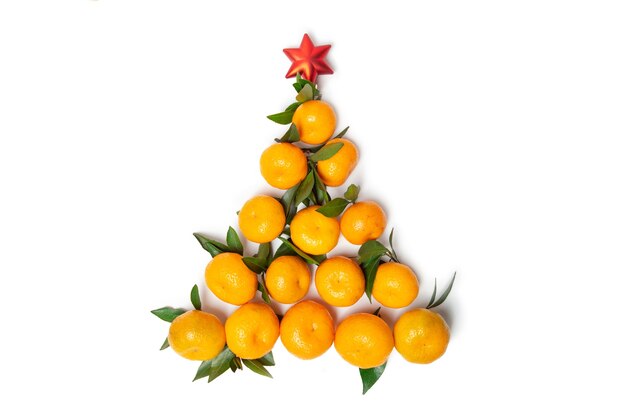Árbol de Navidad creativo hecho de mandarinas sobre un fondo blanco aislado. Estrella roja de Navidad.