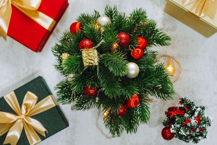 Árbol de Navidad y decoraciones rodeadas de cajas de regalos envueltas con decoraciones de cinta dorada