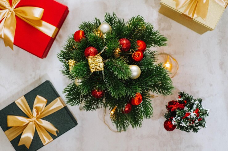 Árbol de Navidad y decoraciones rodeadas de cajas de regalos envueltas con decoraciones de cinta dorada