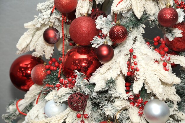 Un árbol de Navidad decorado con adornos y bayas rojas y blancas.