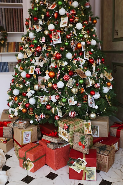 Foto Árbol de navidad decorado con adornos navideños y regalos.