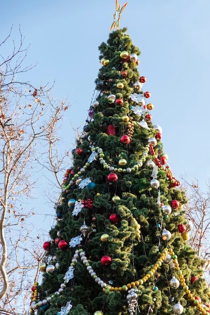 Árbol de Navidad decorado con guirnaldas de juguetes y decoración estrella de Año Nuevo para las vacaciones de invierno